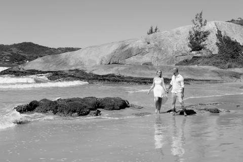 Fotos casal caminhado na praia do Siriu noiva com vestido curto e noivo com camisa bata.'