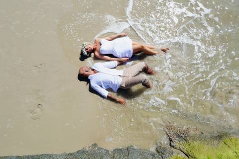 noivos deitados na areia, fotos feitas na praia de Garopaba .'