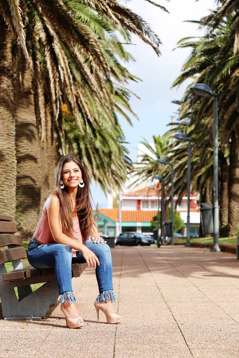 Fotografia-de-Street-Book-de-15-anos-na-praia-de-Punta-del-Este-em-Maldonado-no-Uruguai-modelo-com-blusa-rosa-e-jeans-salto-alto-cor-da-pele-sentada-em-banco-de-praça-em-maldonado-punta-del-este-uruguai-book-quinze-anos-no-uruguai-book-15-anos-em-punta'