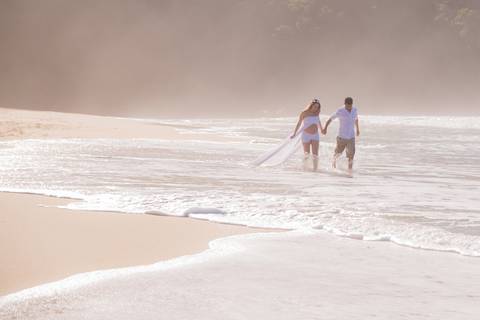 foto de casal com mãos dadas na praia, ensaio gestante'