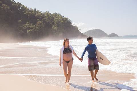 foto de casal com mãos dadas na praia, ensaio gestante'