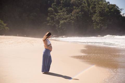 foto de grávida segurando a barriga na praia. ensaio gestante'