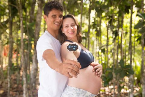 foto de casal segurando placa com o nome do filho. ensaio gestante'
