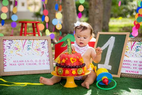 foto do bebê comendo o bolo de frutas no cenário colorido. ensaio smash the cake smash the fuit'