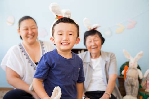 foto de criança com família no cenário decorado com coelhos. mini ensaio fotografia páscoa '