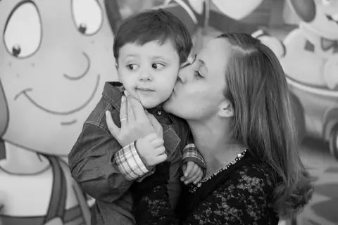 foto preta e branca de criança aniversariante com família. fotografo aniversário'