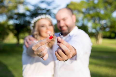 foto de marido e mulher segurando alianças. ensaio casal '