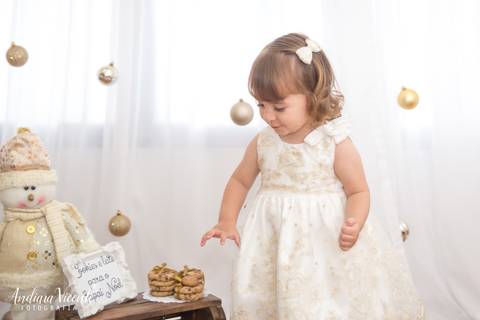 criança pegando um biscoito do cenário. mini ensaio natal fotografia'