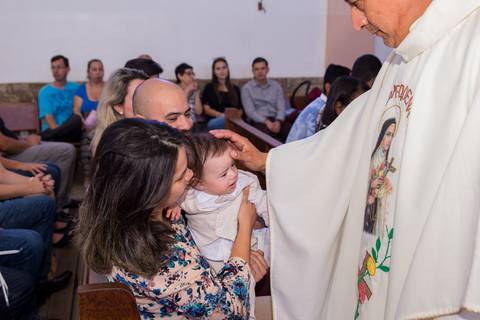 padre com a mão na cabeça do bebê fotografia batizado'