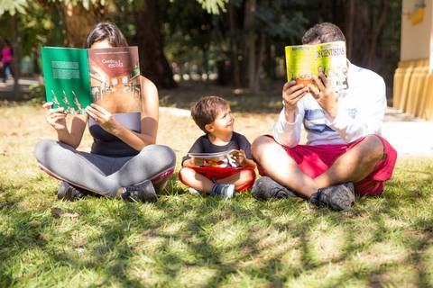 foto de criança lendo com os pais. ensaio família'
