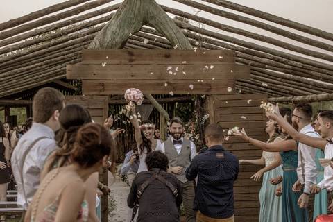 saída dos noivos no click do fotógrafo de casamento Bauru Thiago Figueredo noiva erguendo o buquê e noivo sorrindo'