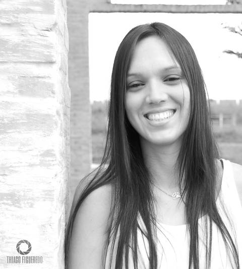 Sorriso contagiante da Priscila em seu ensaio fotográfico pelo fotógrafo de ensaio de Jaú encostada no murinho, foto em preto e branco'