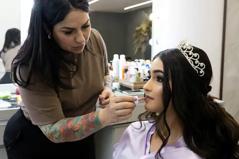 Fotógrafo de 15 anos capturando os detalhes da maquiagem e do penteado de Leticia, eternizando os preparativos para a festa de 15 anos'