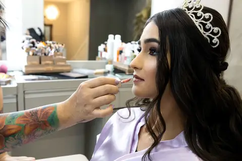Fotógrafo de 15 anos capturando os detalhes da maquiagem e do penteado de Leticia, eternizando os preparativos para a festa no Spazio Golf'