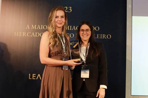 Vencedora discursando no púlpito durante o BRALLAW 2023. Contrate um fotógrafo de eventos corporativos que captura com profissionalismo os discursos e a emoção dos momentos de premiação em São Paulo.'