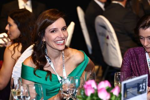 Convidada sorrindo durante o jantar de gala do BRALLAW 2023. Contrate um fotógrafo de eventos que captura a alegria e a experiência positiva dos seus participantes, valorizando o sucesso do seu evento corporativo em São Paulo.'