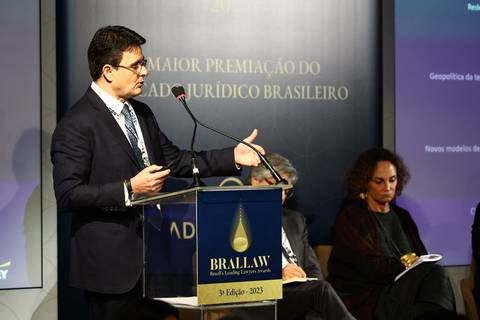 Palestrante discursando no palco do BRALLAW 2023. Contrate um fotógrafo de eventos corporativos que registra com profissionalismo os momentos-chave e as apresentações da sua premiação em São Paulo.'