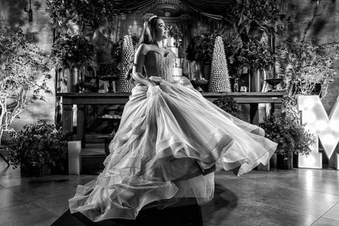 Foto artística em preto e branco da debutante girando o vestido na Casa Bertolazzi Santana, por fotógrafo de festa de 15 anos em SP.'