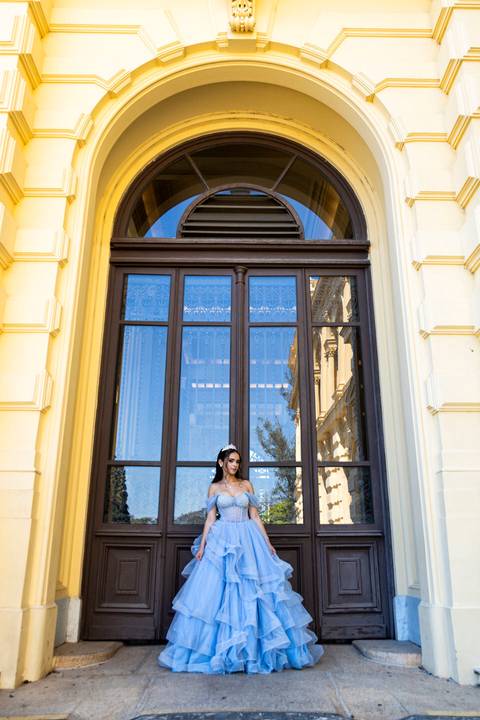 Cena completa do ensaio de 15 anos, com debutante e a arquitetura do Museu do Ipiranga ao fundo.'