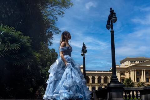 Debutante caminhando pelos jardins do Museu do Ipiranga durante seu ensaio de 15 anos.'