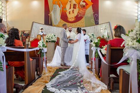Momento da benção dos noivos na Igreja, mostrando detalhes do vestido da noiva'