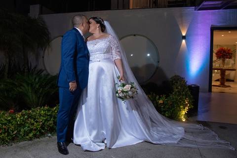 Beijo do noivo na noiva na fotografias externa após cerimonia.'