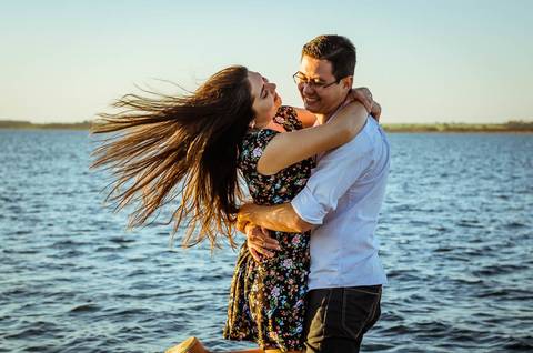 Fotografia do ensaio de casal se abraçando, ao fundo está o rio Tietê.'