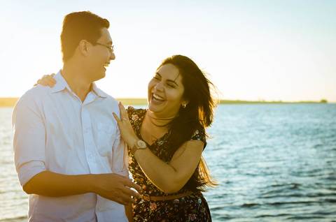 Foto do casal juntos se divertindo, ao fundo está o rio.'