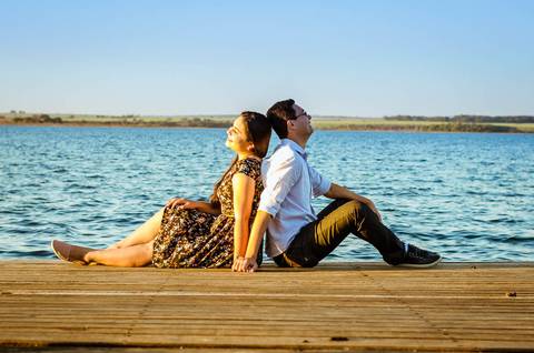 Fotografia do casal sentados em um flutuante sob o rio Tietê.'