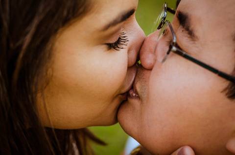 Fotografia do casal se beijando bem de perto.'