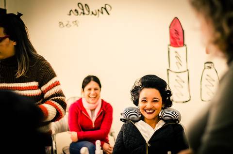 Fotografia de casamento do making of da noiva no salão de beleza no dia da noiva arrumando o cabelo. Ela sorri com alegria em Araçatuba SP'