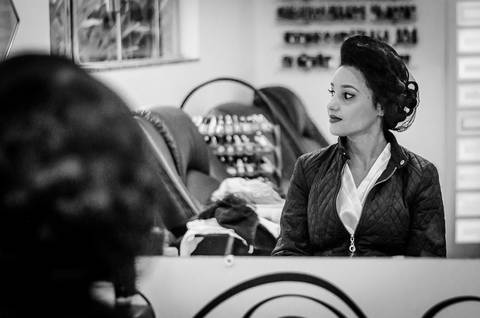 Fotografia de casamento do making of da noiva no salão de beleza no dia da noiva. A noiva está arrumando o cabelo frente ao espelho, em Araçatuba SP'