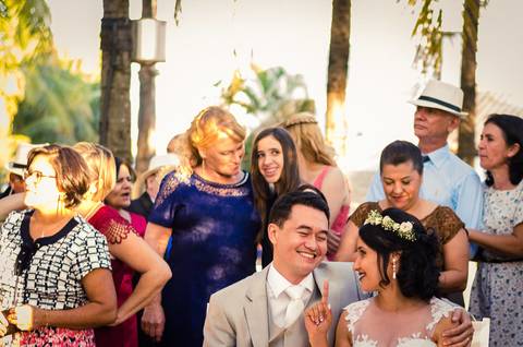 Fotografia de casamento com cerimônia e festa e recepção ao ar livre durante o dia no Califórnia Eventos em Araçatuba SP. Os noivos sentados assistindo ao same day edit'