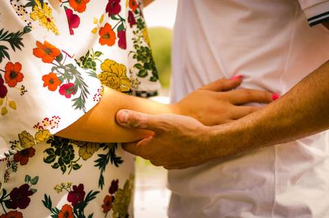 Foto de um casal bem próximos tocando as mãos em Maringá, PR'