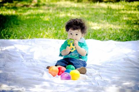 pedro brincando com bolinhas na grama'