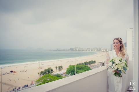 noiva posando na janela com vista para a praia'