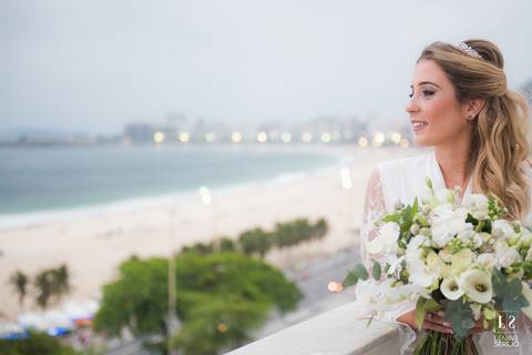 noiva posando na janela com vista para a praia'