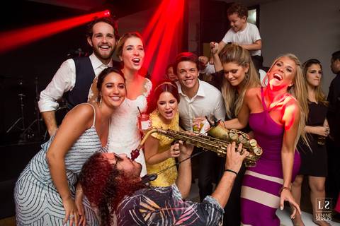 noivos e amigos posando com artista'