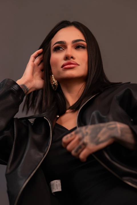 Ensaio fotográfico feminino Curitiba. Jaqueta de couro aberta, pose natural, expressão segura. Marco Lourenço.'