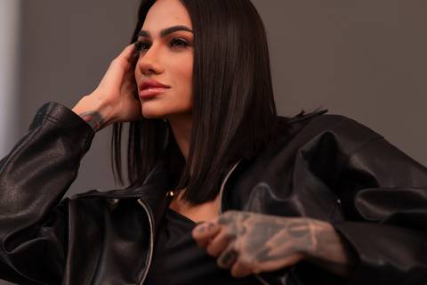 Detalhe de pose com jaqueta de couro, tatuagem visível, iluminação flash. Marco Lourenço'
