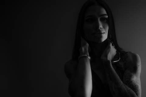 Fotografia feminina preto e branco estúdio Curitiba. Close expressivo, luz dramática, estilo editorial. Marco Lourenço.'