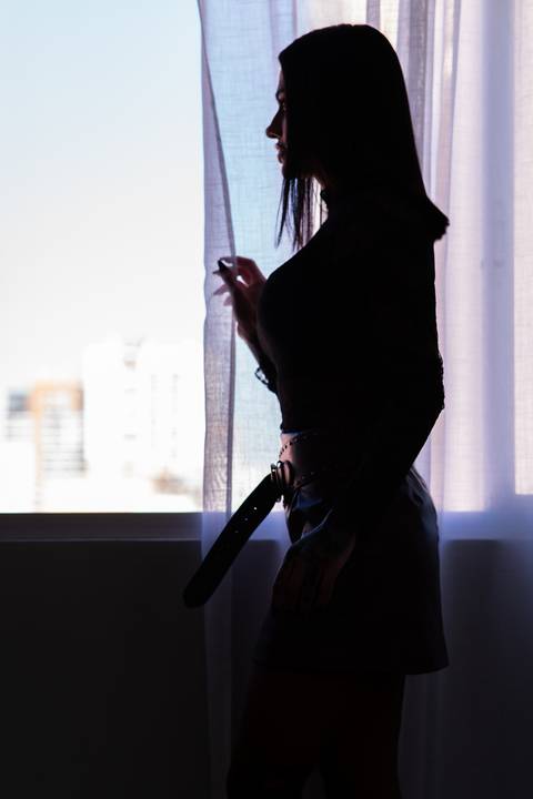 Ensaio feminino contraluz estúdio Curitiba. Silhueta completa com luz de janela, estilo cinematográfico. Marco Lourenço Fotografia.'