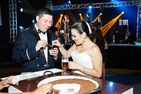 Noivos comendo um brigadeiro na festa'