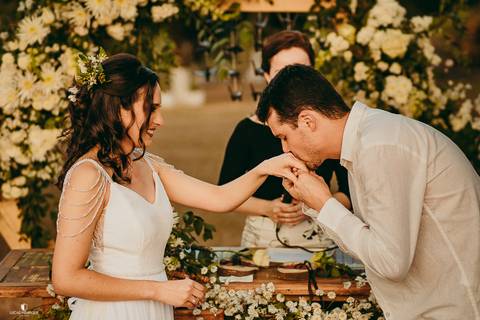 NOIVO BEIJANDO A MÃO DA NOIVA DEPOIS DE COLOCAR AS ALIANÇAS'