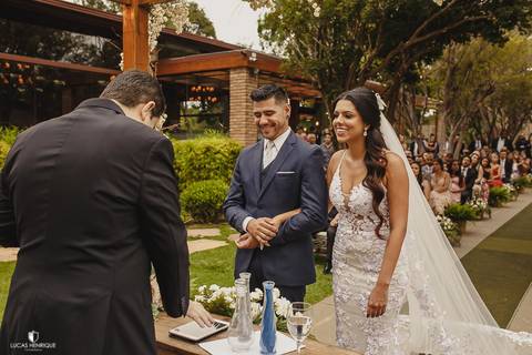 NOIVOS SORRINDO DURANTE A CERIMONIA DE CASAMENTO'