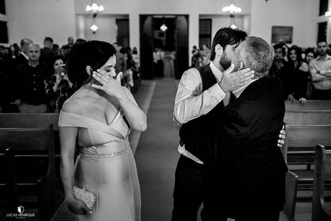 NOIVO ABRAÇANDO OS PAIS NA ENTRADA DO CASAMENTO'