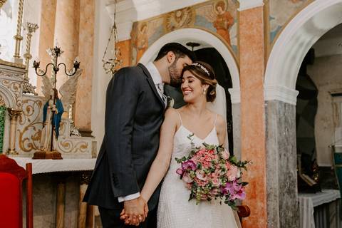 noivo beijando noiva no altar'