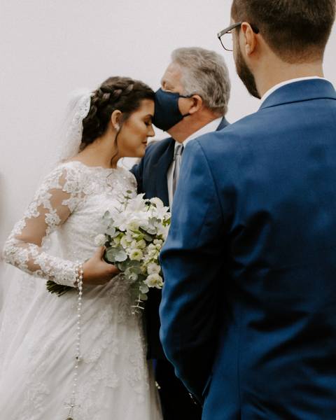 casamento pai da noiva no altar beijando a testa da filha com máscara covid 19'