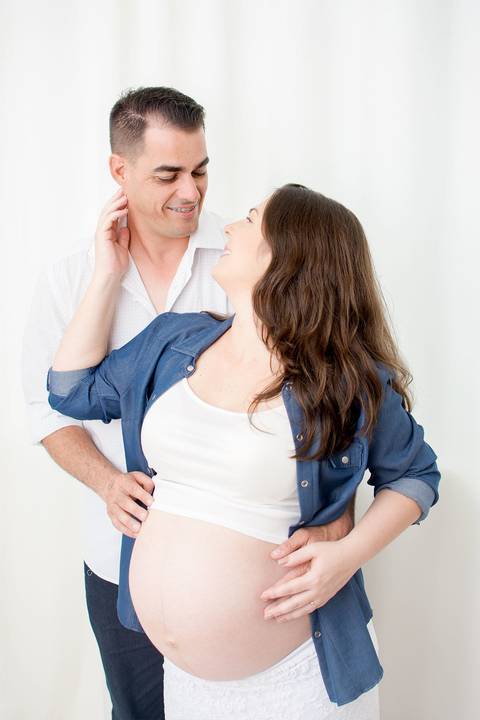 uma gravida de gemeas duas meninas esta abraçada com seu marido pai das meninas por nailie lucchesi e estudio amora '