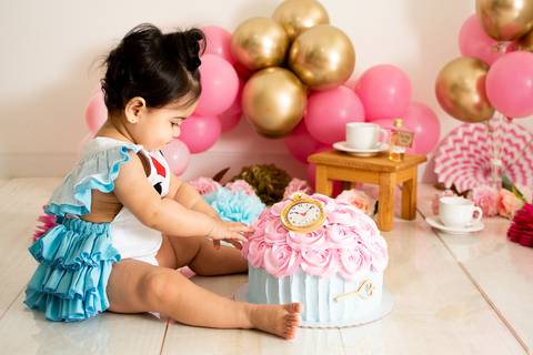 Smash the cake da alice realizado em são josé dos campos com baloes rosa e dourado, com um bolo em formato de cup cake '